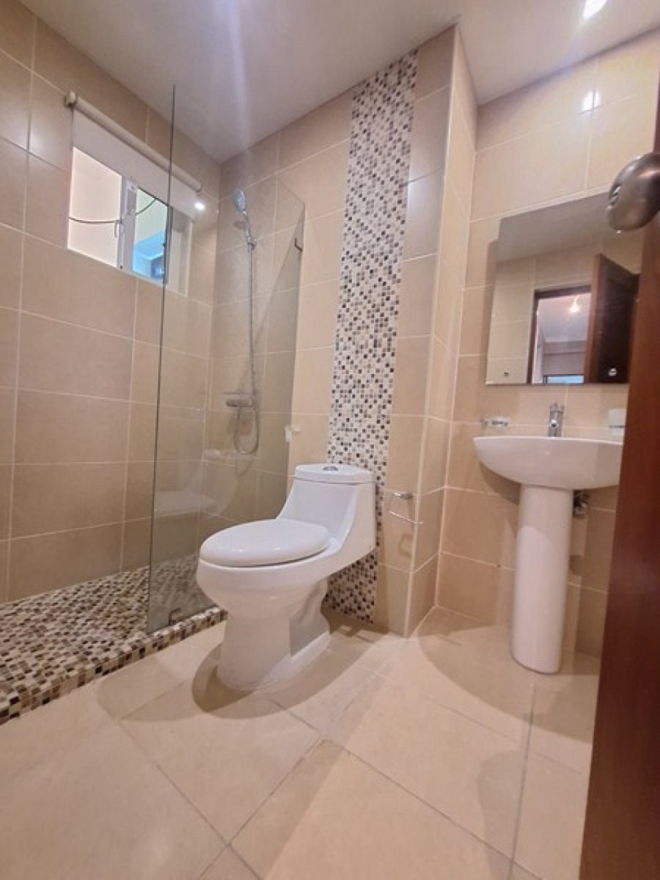 Second bathroom with beige tile and glass shower