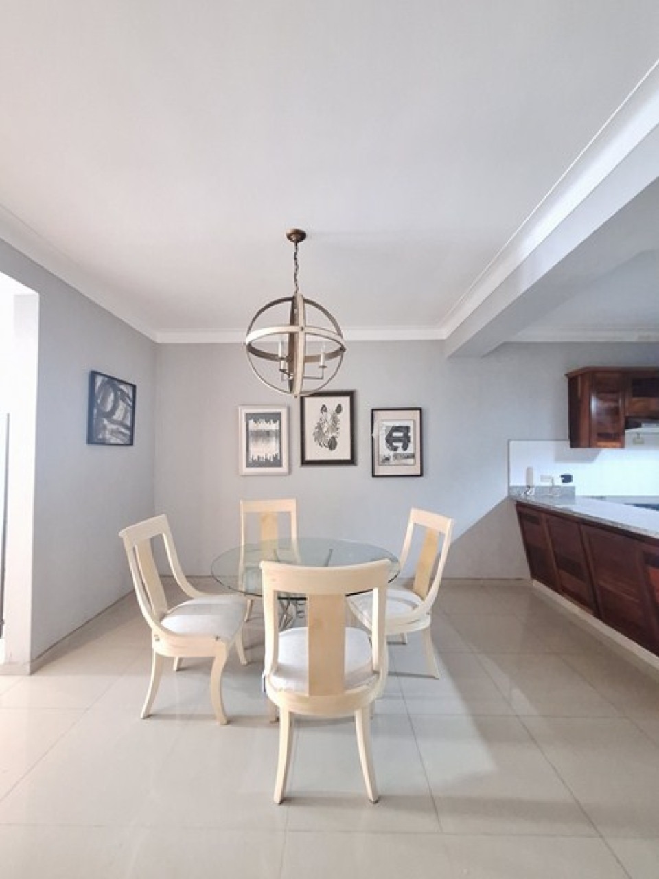 Dining area with round glass table and pendant light