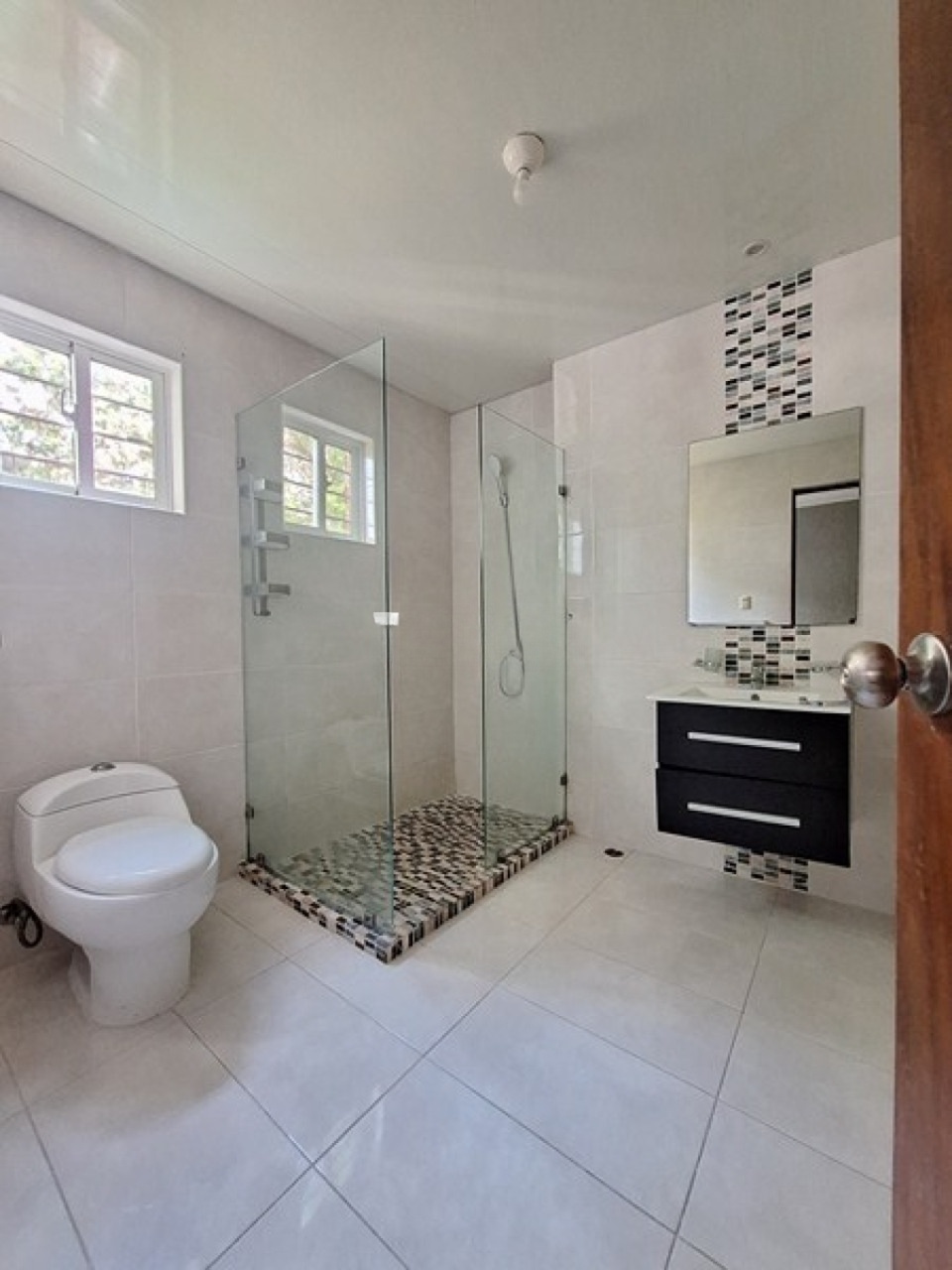 Bathroom with glass shower and mosaic tile